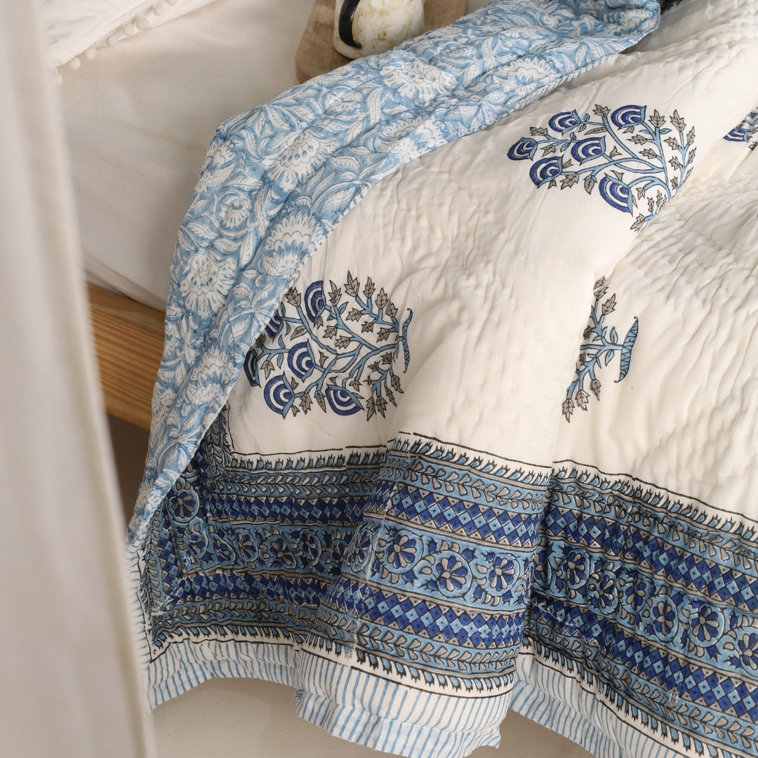 Reversible quilt detail with blue vine print panels and dark blue border