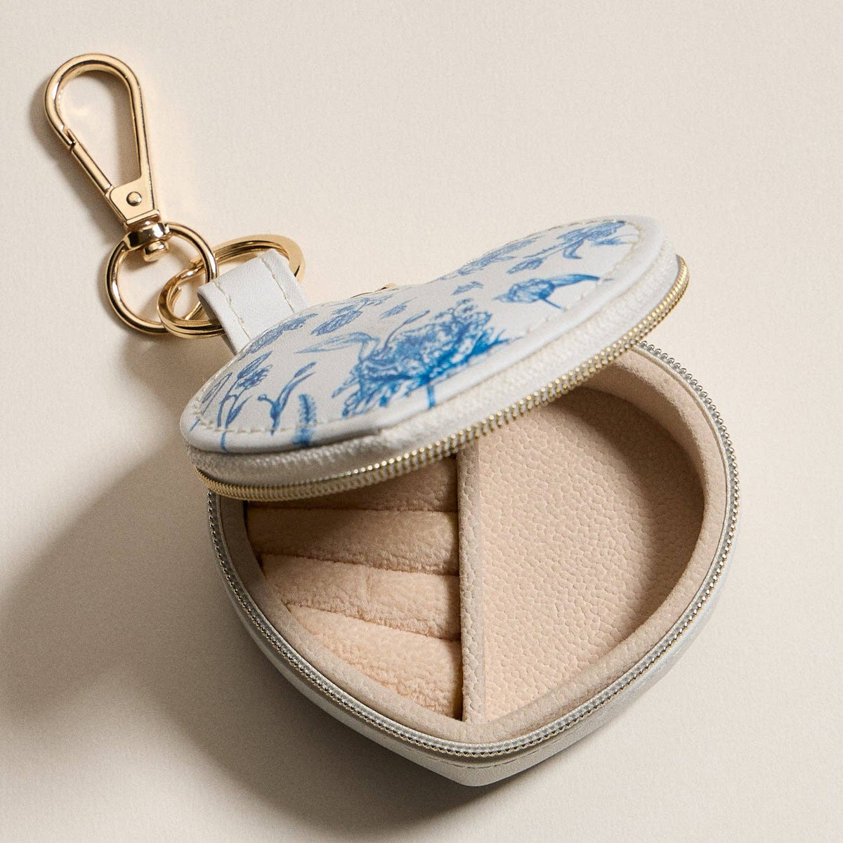 Heart-shaped jewelry travel case open, blue floral top, with metal keychain ring