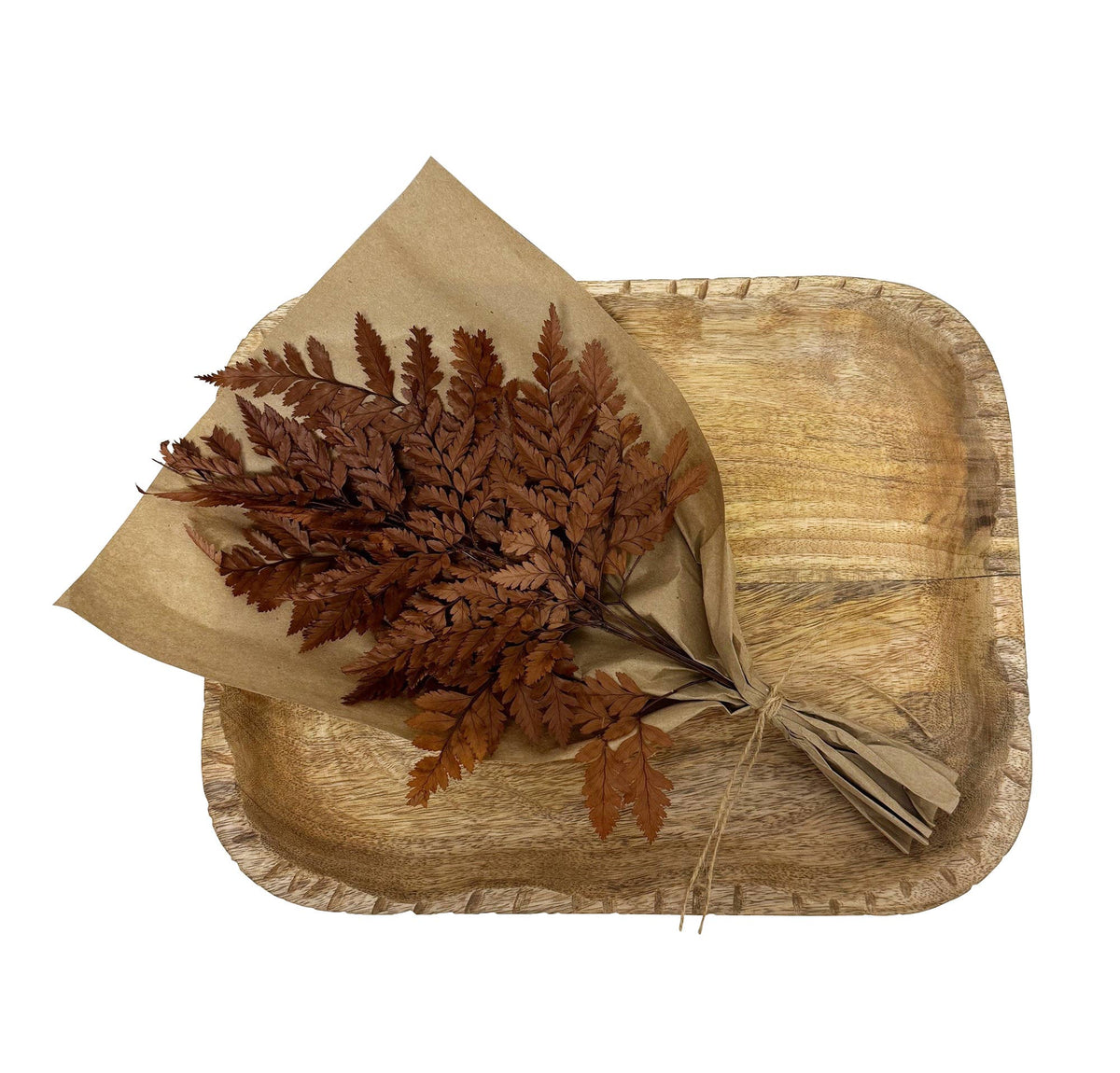 Dried leaf bundle in kraft paper on a wooden tray, mahogany brown foliage