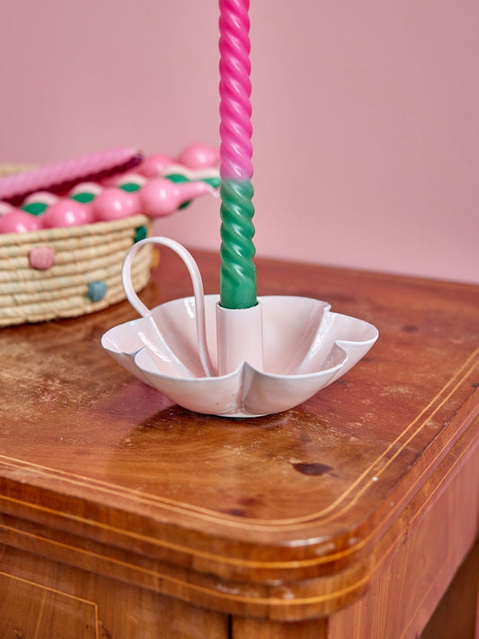 Soft pink metal flower candle holder with central cup holding a twisted candle