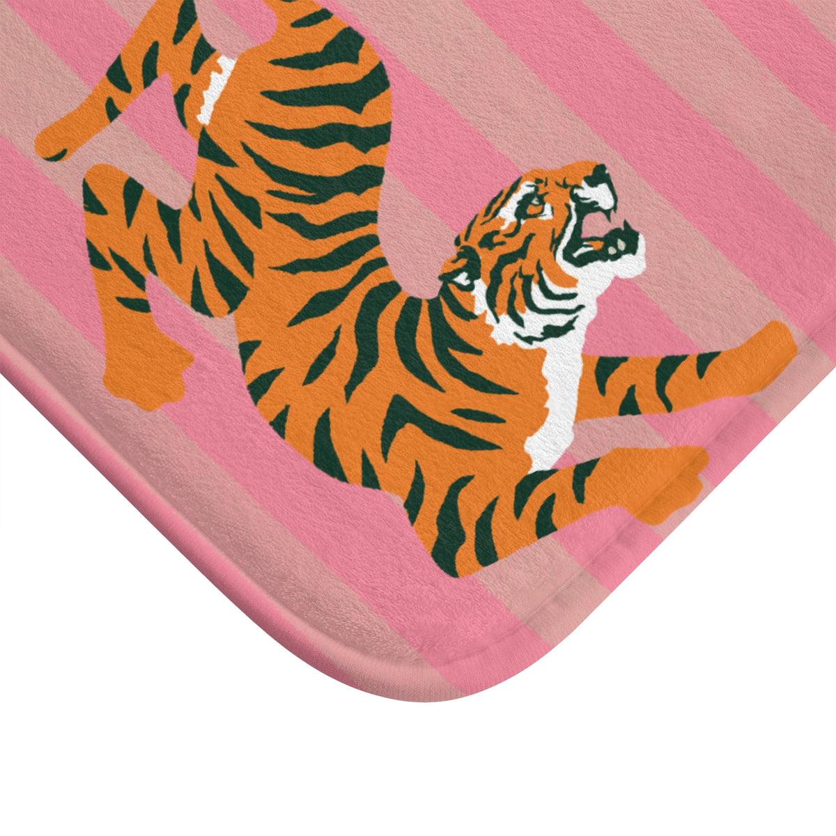 Close-up corner of pink striped bath mat with orange and black tiger artwork