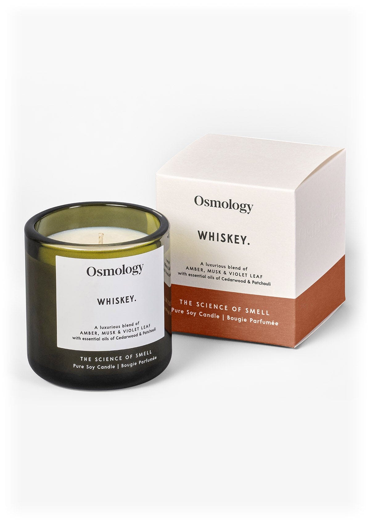 Scented candle in dark glass jar with green wax and label, with matching gift box