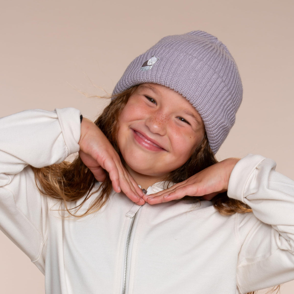 Gray fox-embroidered beanie worn by a child, showing the ribbed cuff