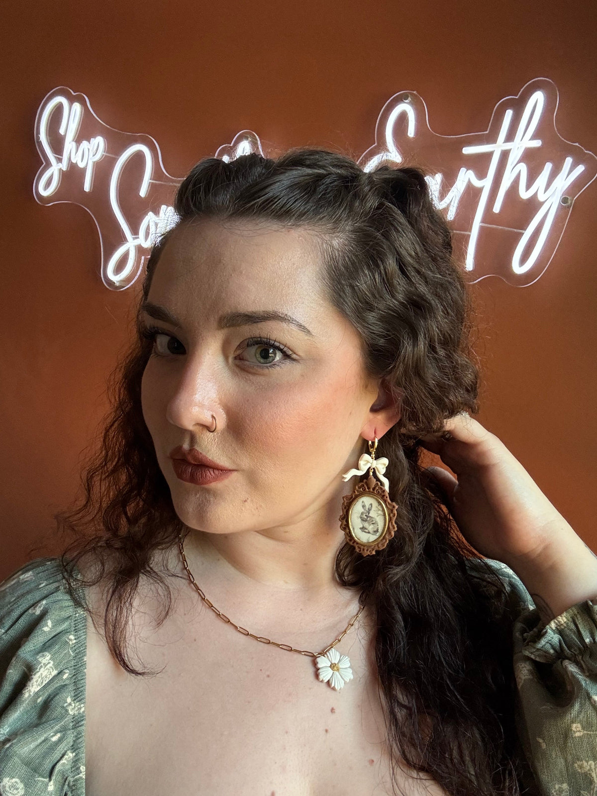 Vintage rabbit frame drop earrings with white flower details, worn by model, gold hooks