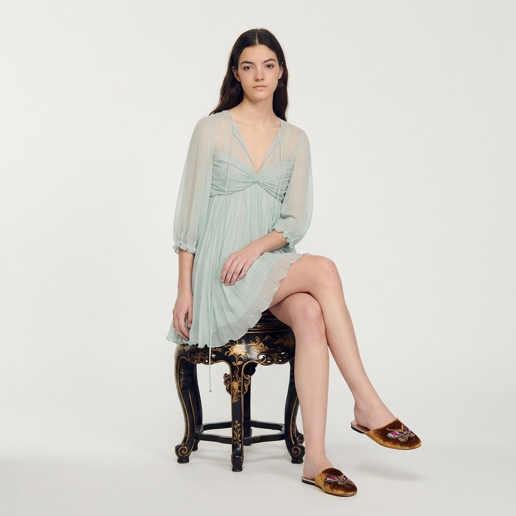Model wearing antique gold velvet mules with butterfly embroidery