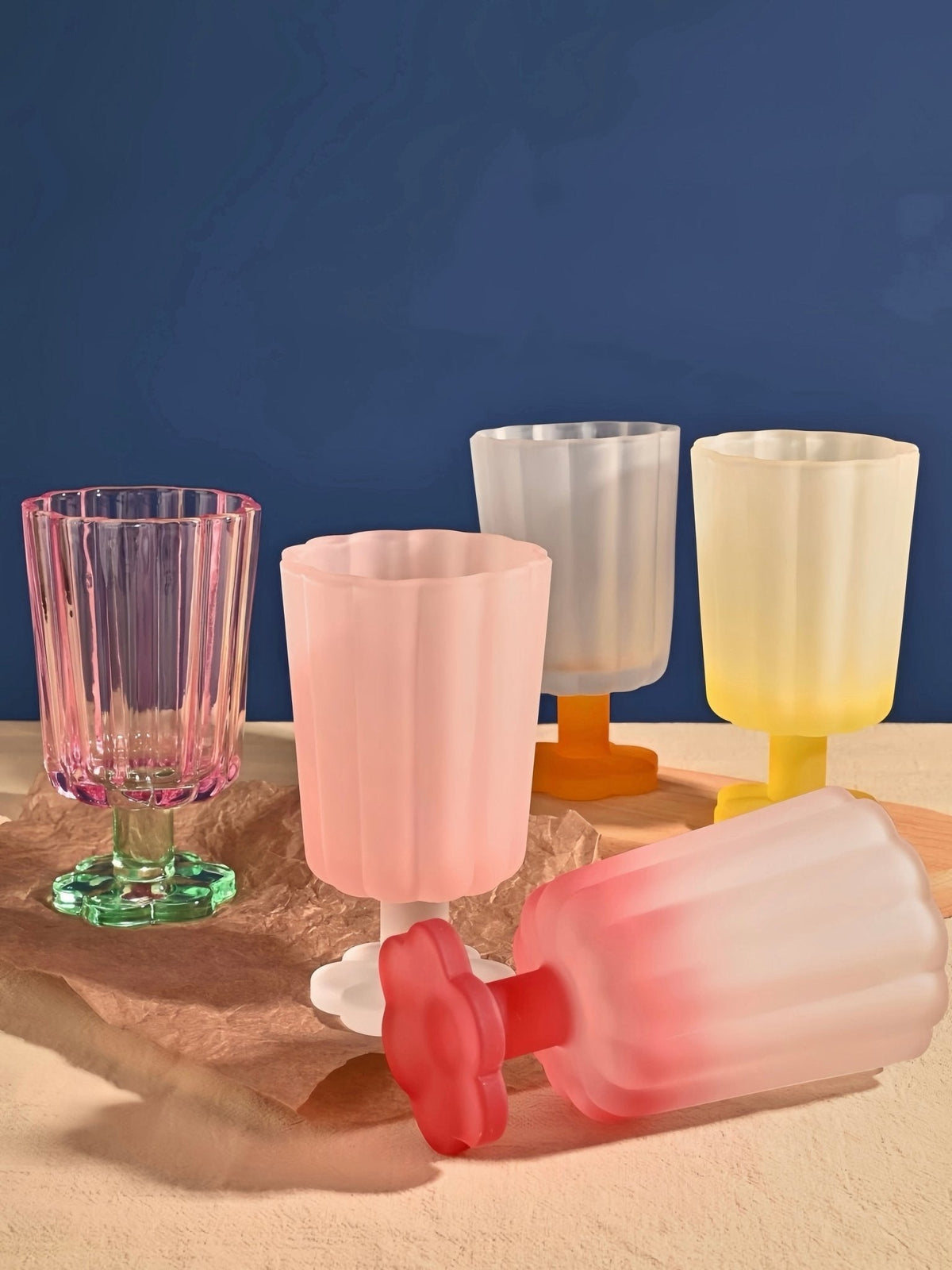 Hand-blown petal goblet glasses in pink, peach, blue, and clear, with color bases.