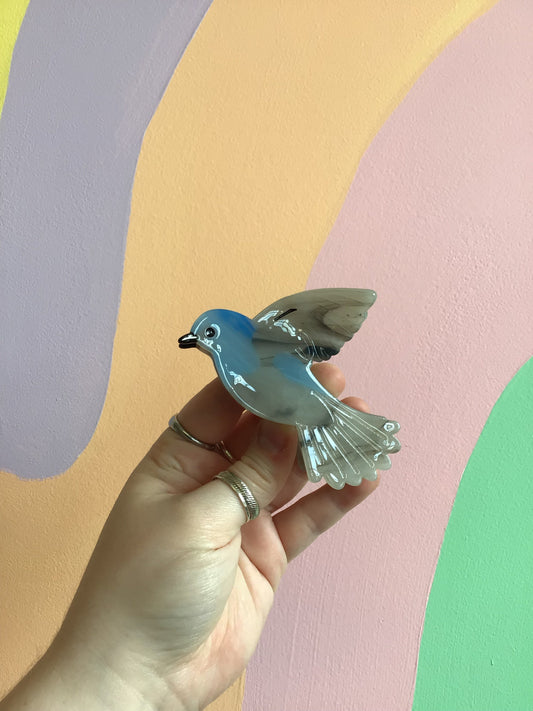 Blue bird hair claw with wing-shaped design and glossy finish