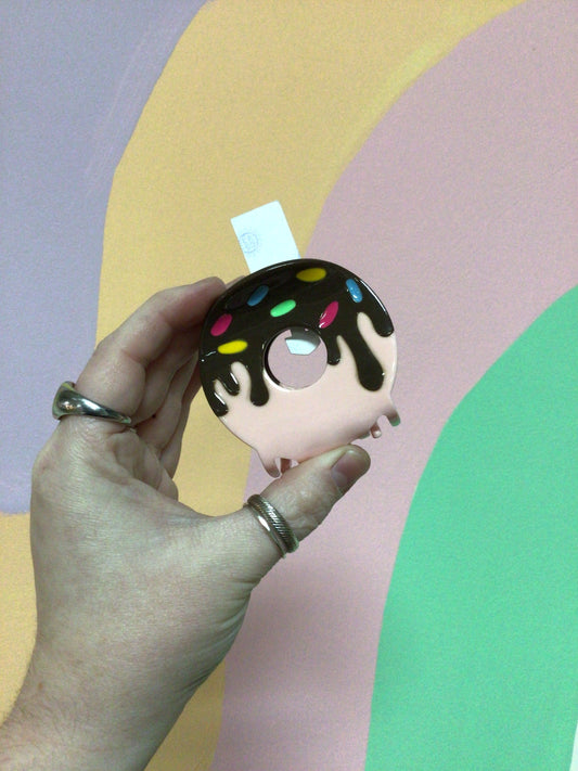 Donut-shaped hair claw with dark frosting and blue sprinkles detail