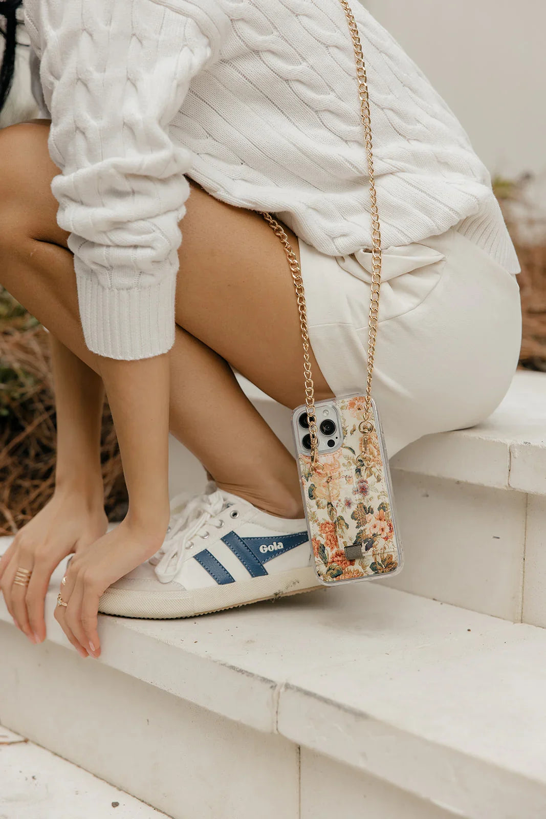Close-up floral phone purse case with gold chain and clear camera cutout