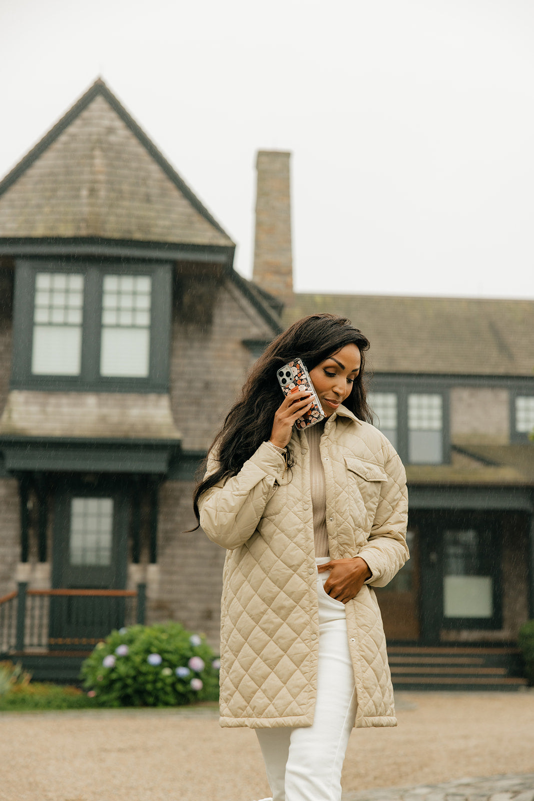Floral iPhone phone case with brown strap, held up to the face