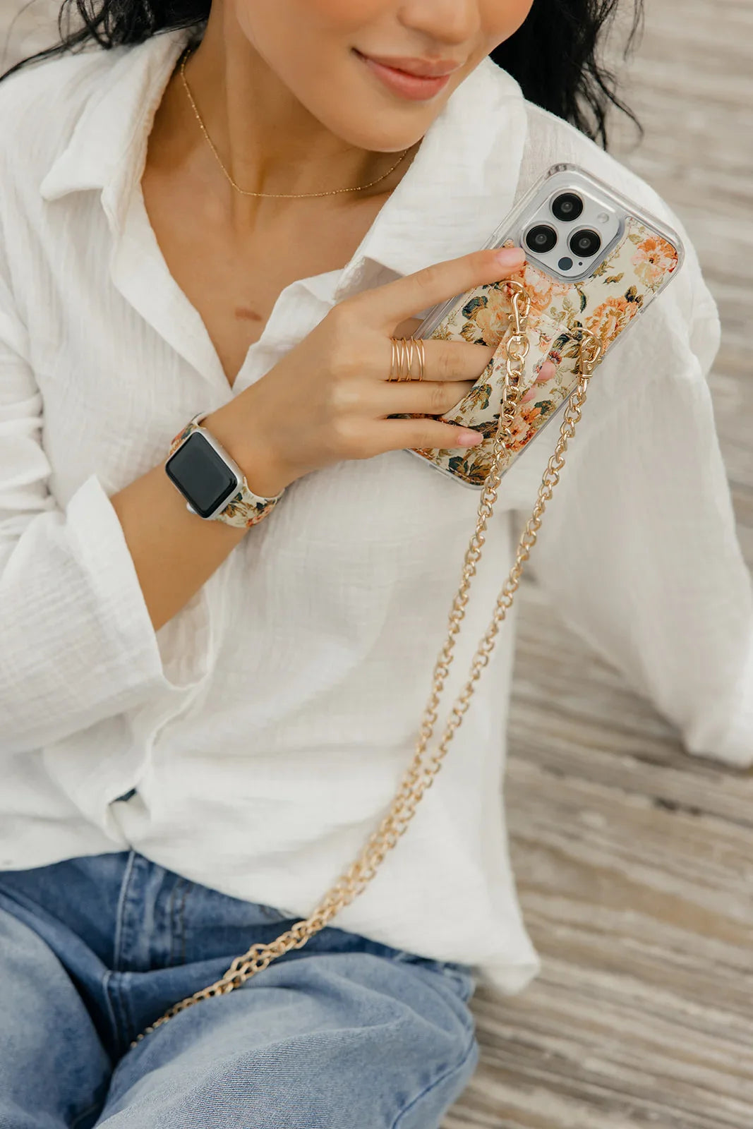 Close-up floral phone purse case with clear camera area and gold chain