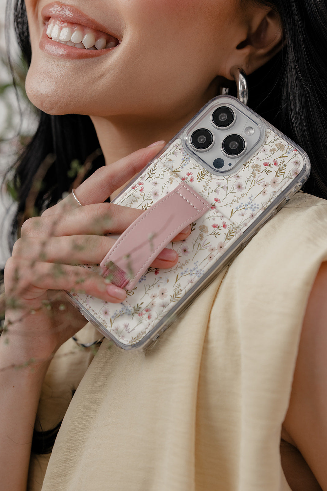Floral clear phone case with mauve strap, front held; multiple camera cutouts visible