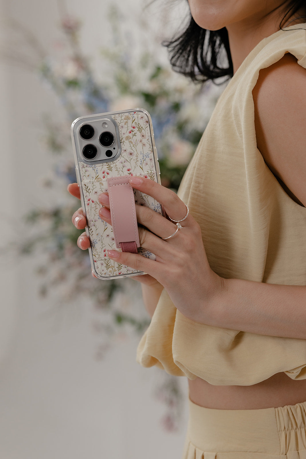 Floral phone case with mauve strap and transparent border; camera cutouts on back