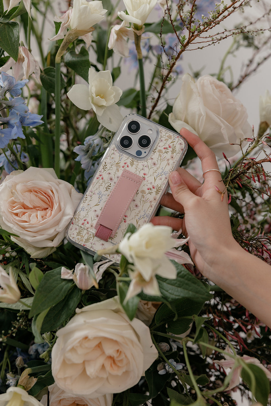 Floral phone case with mauve strap accessory; transparent edges visible