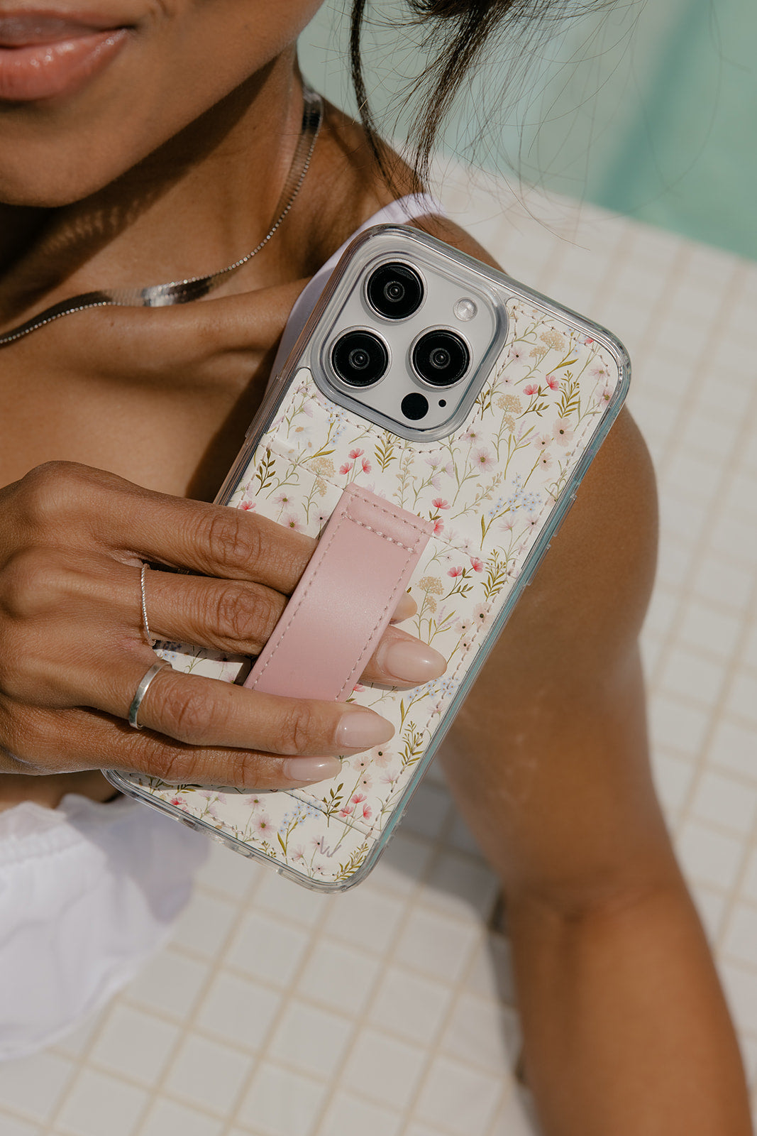Floral clear phone case with mauve strap and camera openings; slim side grip