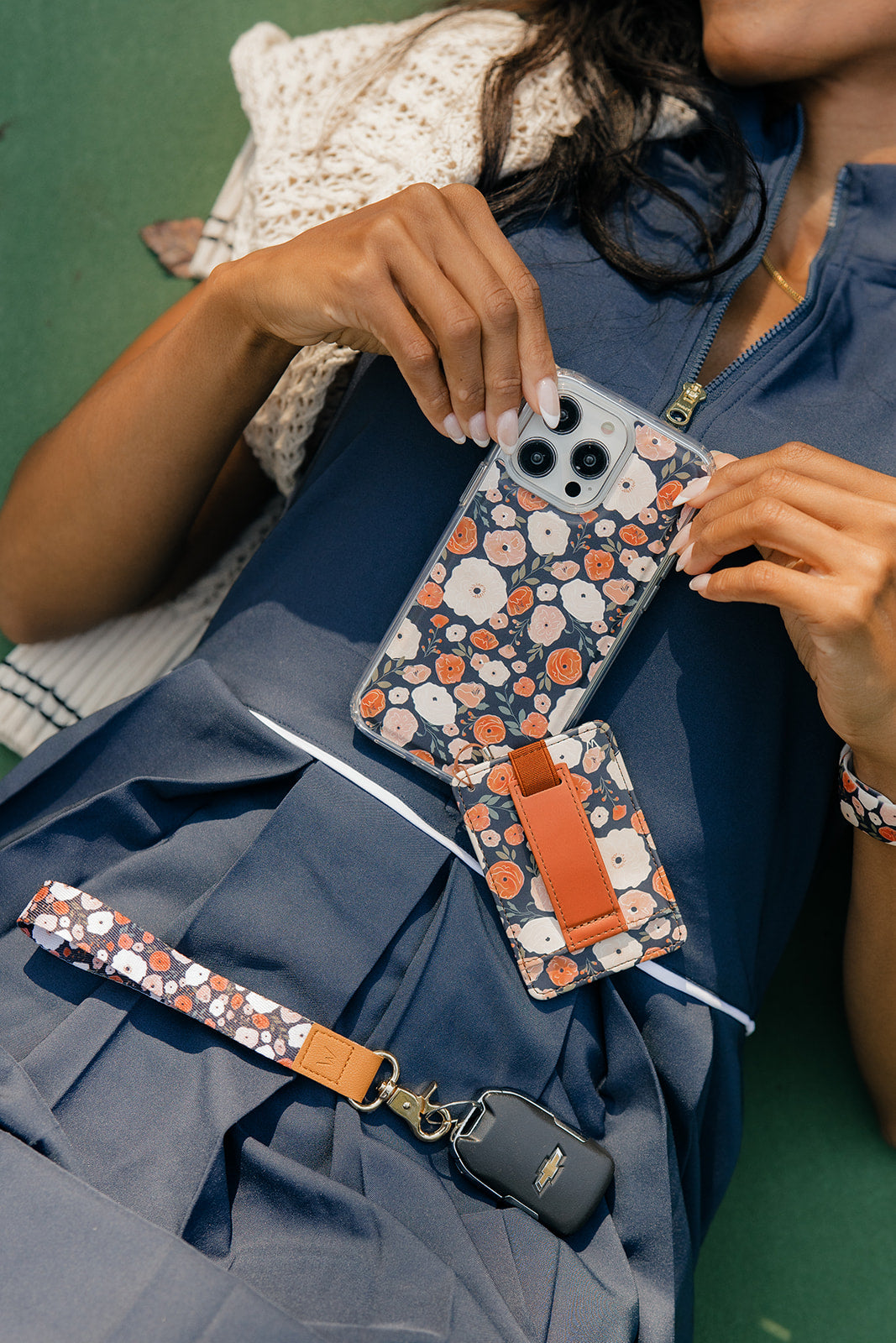 Owl floral wrist lanyard with tan leather ends holding a phone