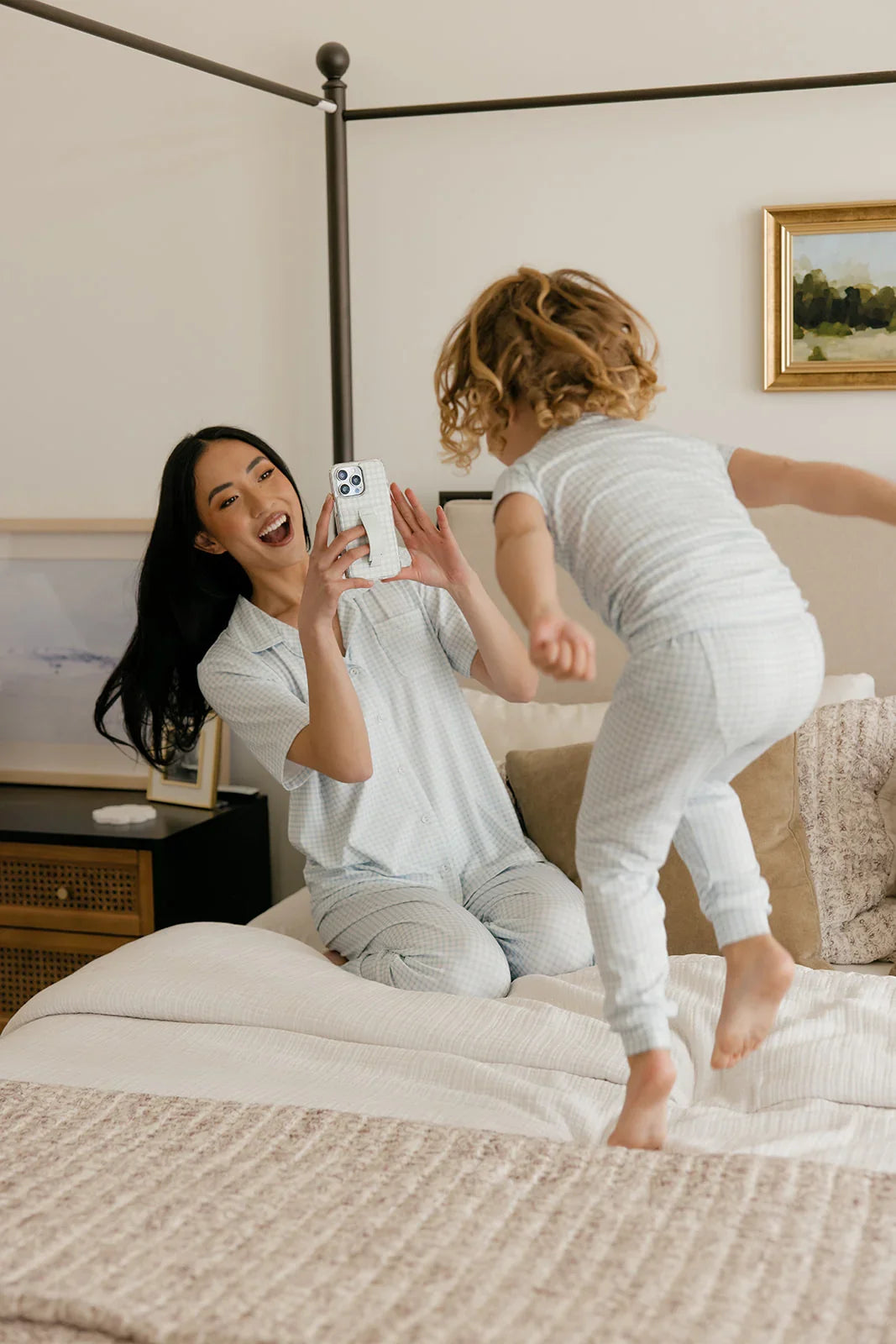 Light blue gingham phone case with strap, woman holding phone while hugging a child