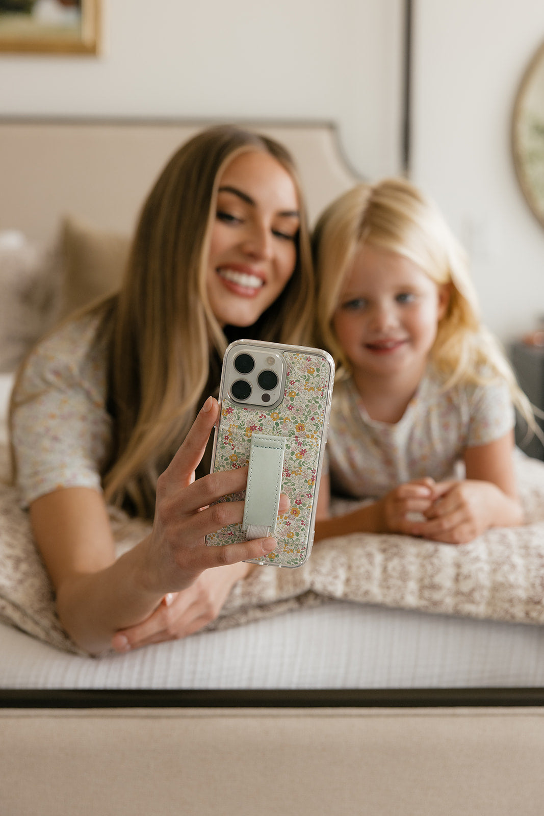 Petal Garden floral phone case with wrist strap, held by woman