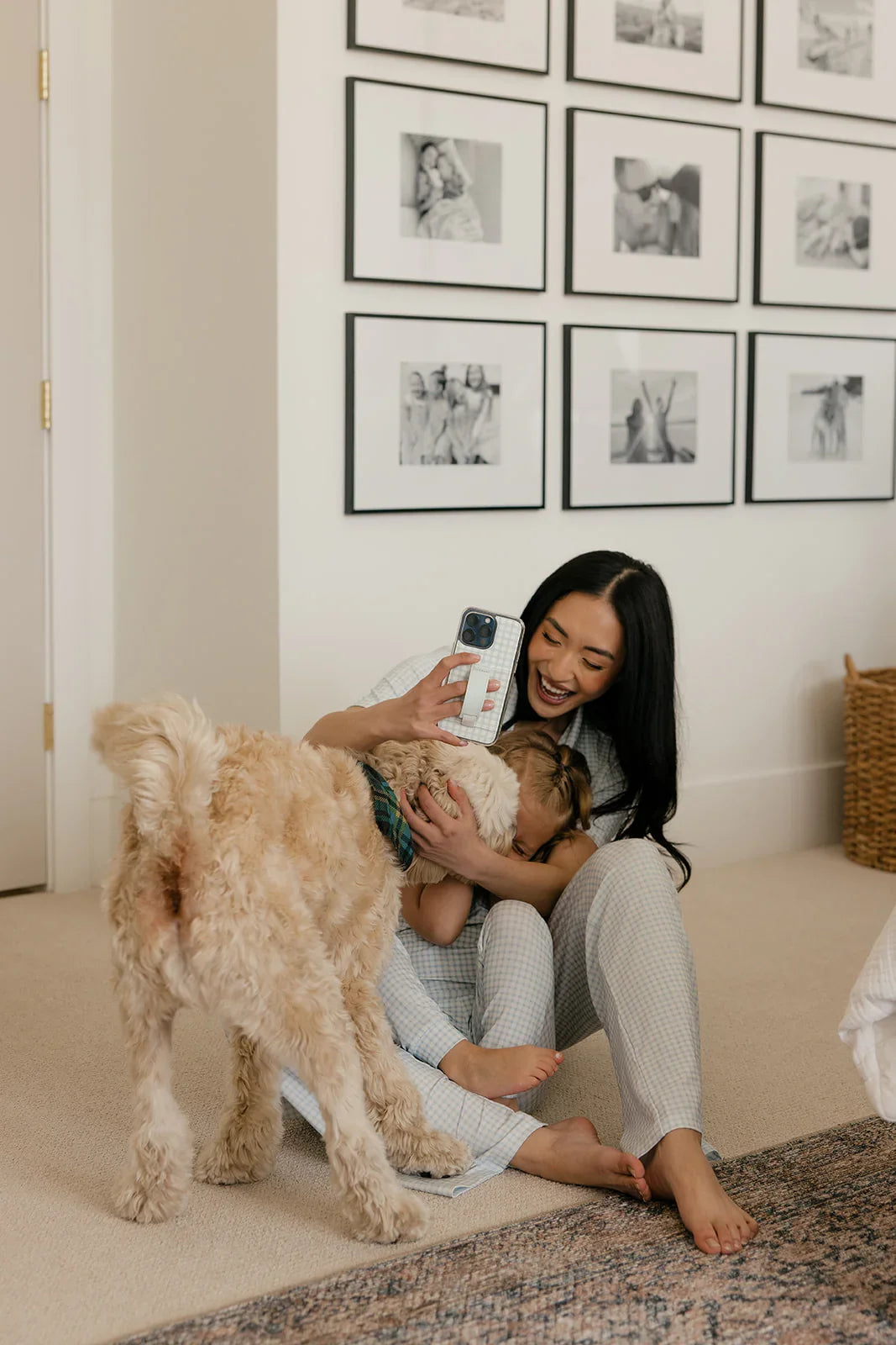 Light blue gingham phone case with strap, woman holding a phone while holding a child