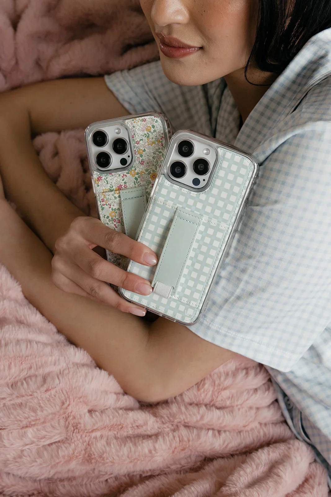 Mint gingham phone case with clear backing and strap, held with a floral case