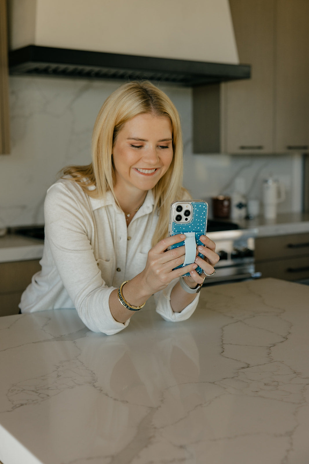 Teal phone case with white speckles and strap holder on a smartphone