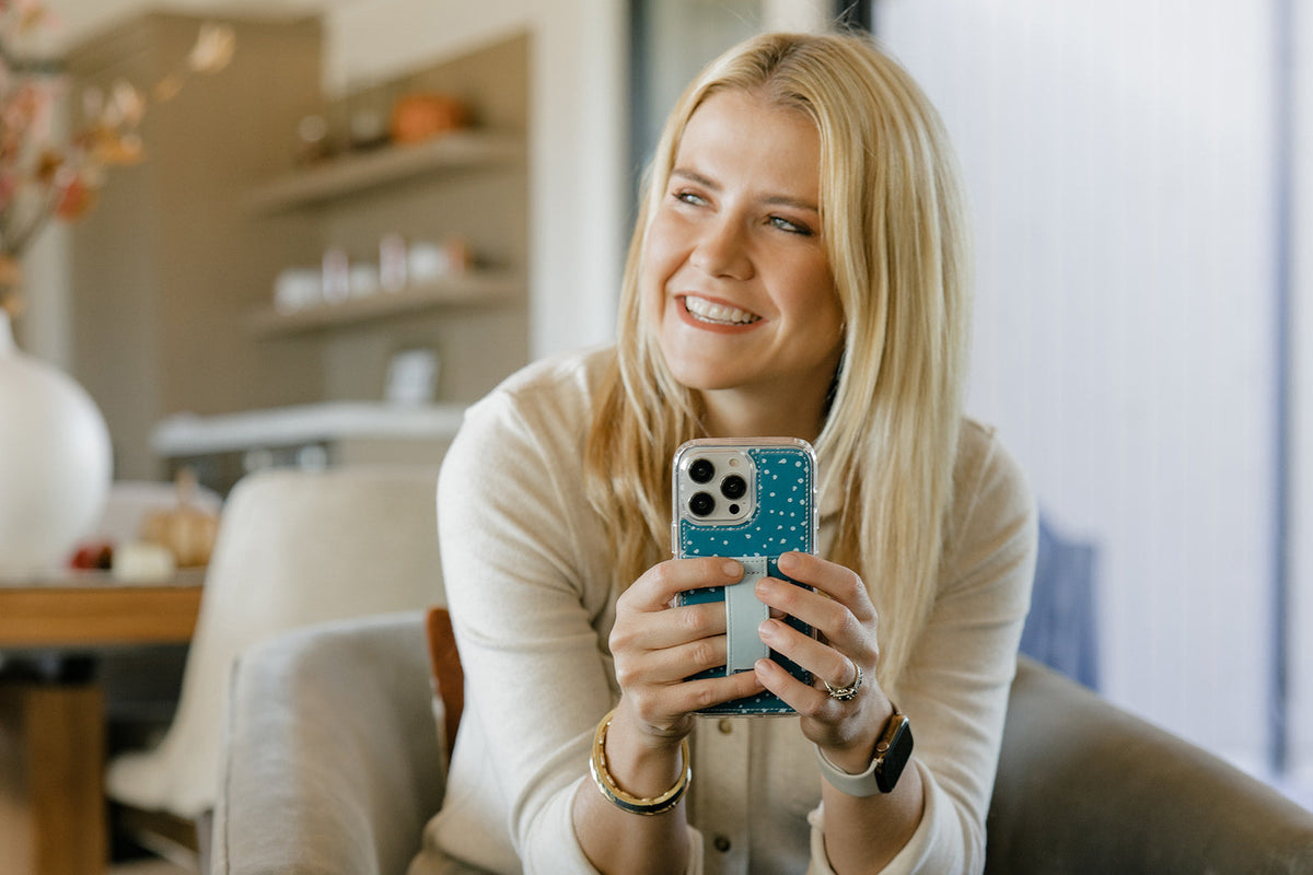 Teal speckled phone case with light blue strap holder on a smartphone