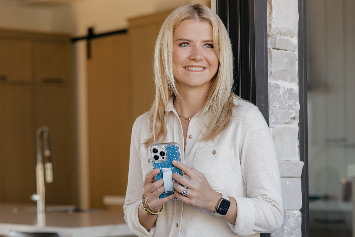 Teal speckled phone case with light blue strap holder on a smartphone