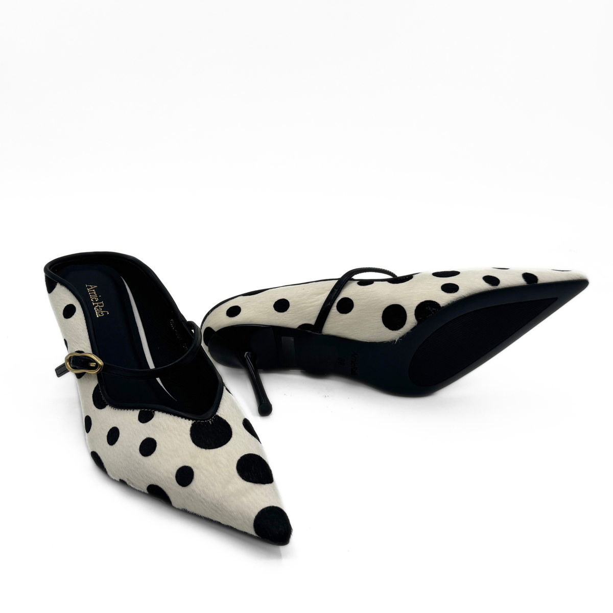 Polka-dot pony hair pumps showing pointed toe, black heel, and sling strap.