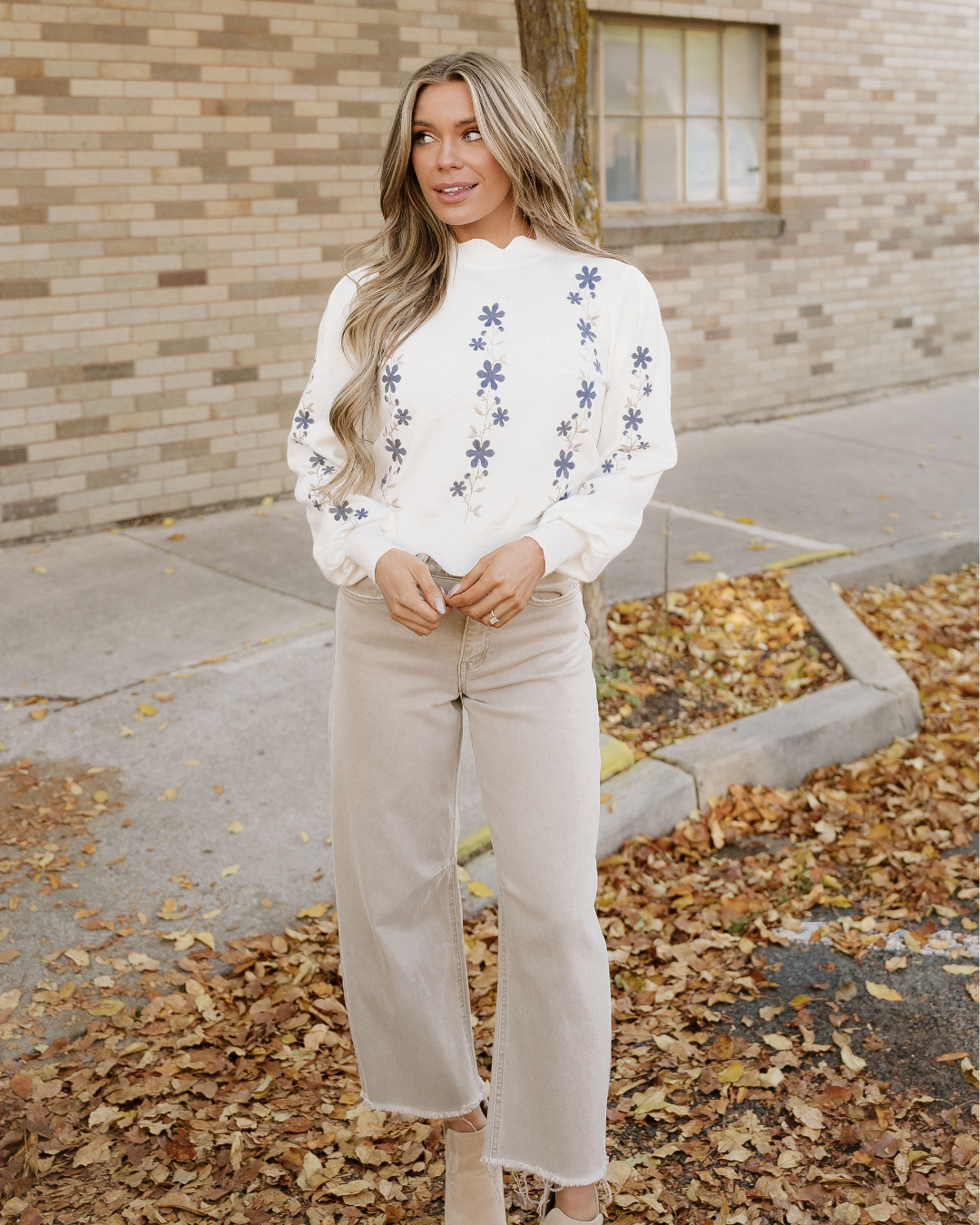 White cropped sweater with blue floral embroidery and relaxed fit