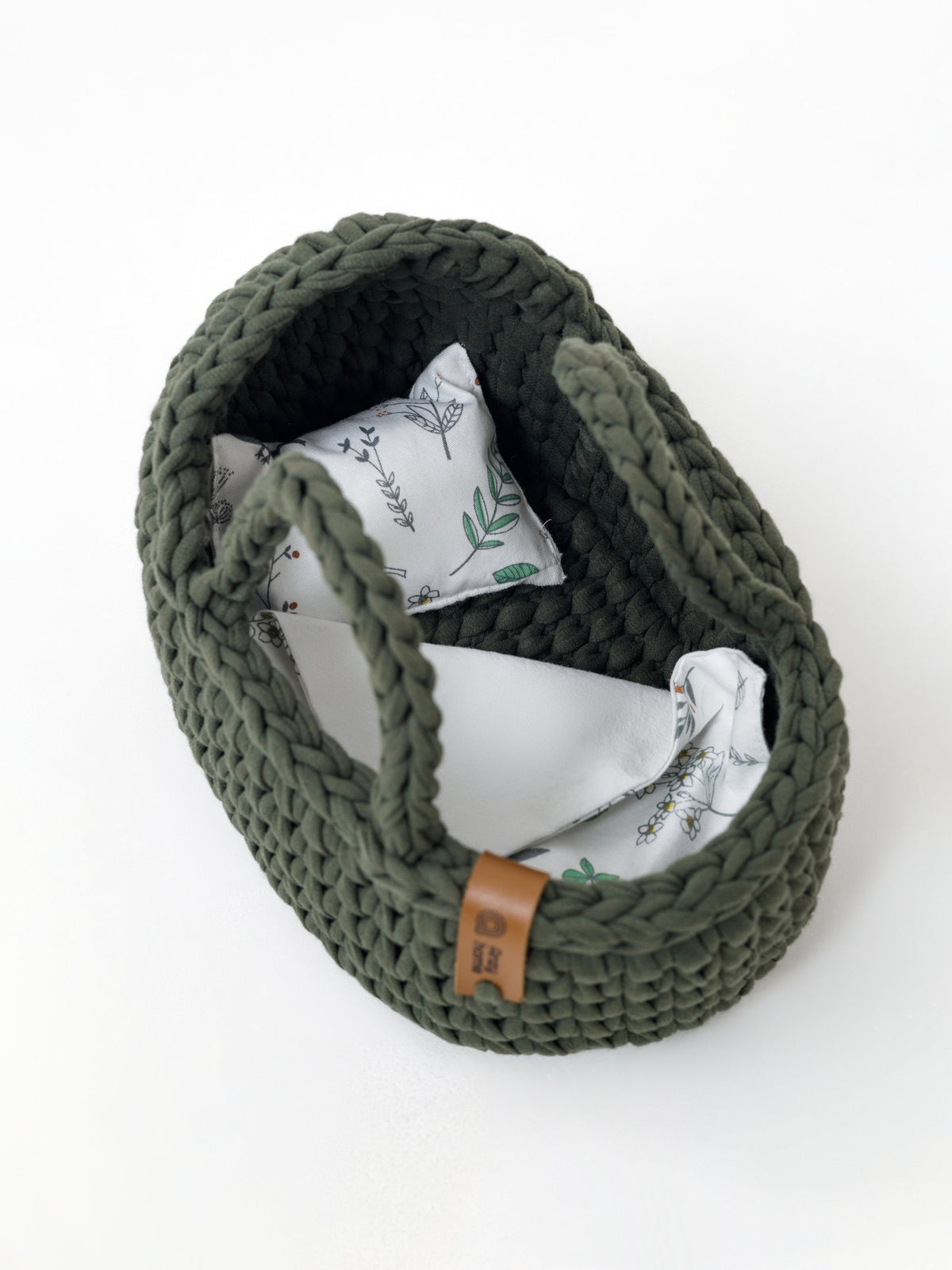Green crocheted mini doll moses basket with patterned inner pad and handles
