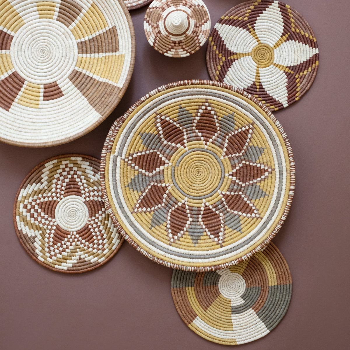 Set of round woven coasters with flower-burst radial beadwork in cream and brown