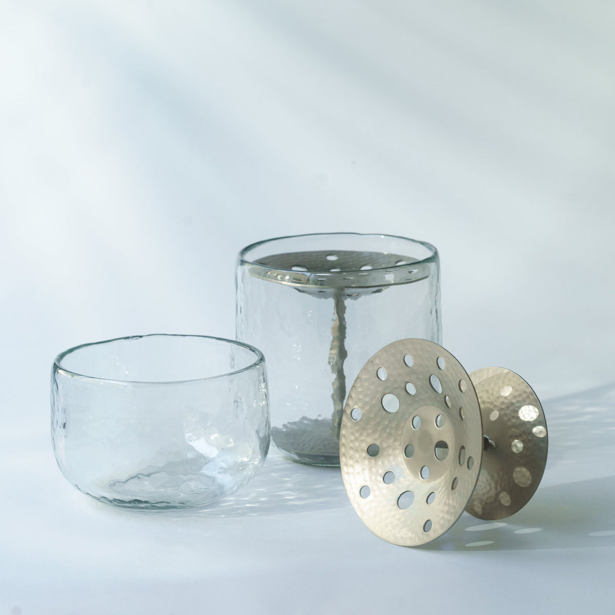 Clear glass vase with perforated flower frog insert and round perforated metal cover