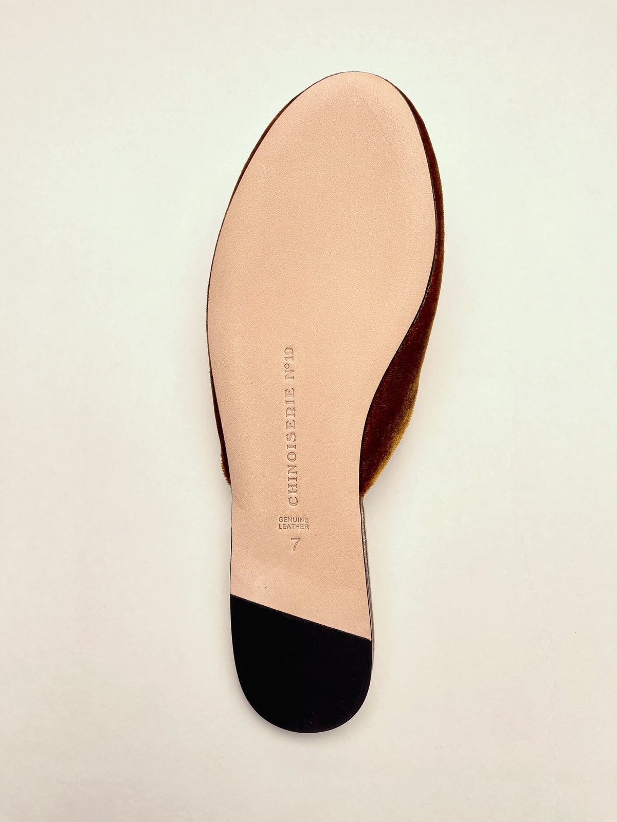 Side view of antique gold velvet mules with red interior and smooth sole