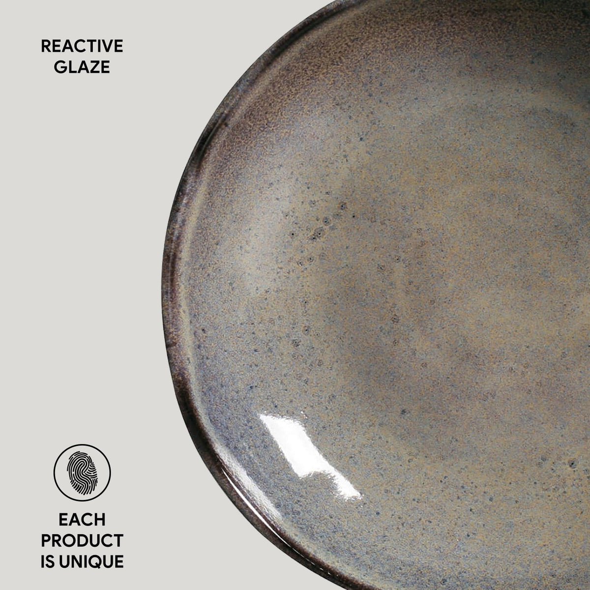 Reactive glazed pasta plate, round edge view, dark gray-green speckled surface
