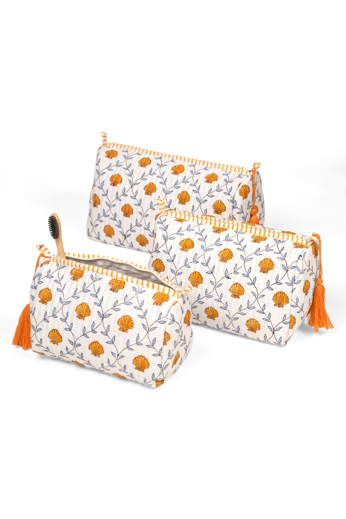 Set of two blockprint makeup bags in white with orange daisy-like flowers, tassel pulls