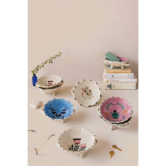 Set of footed bowls with mixed colorful prints and scalloped rims, cream bases.