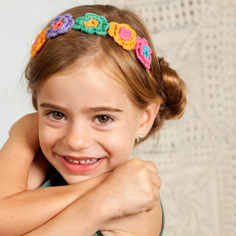 Bright multicolor knitted flower headband worn by a child