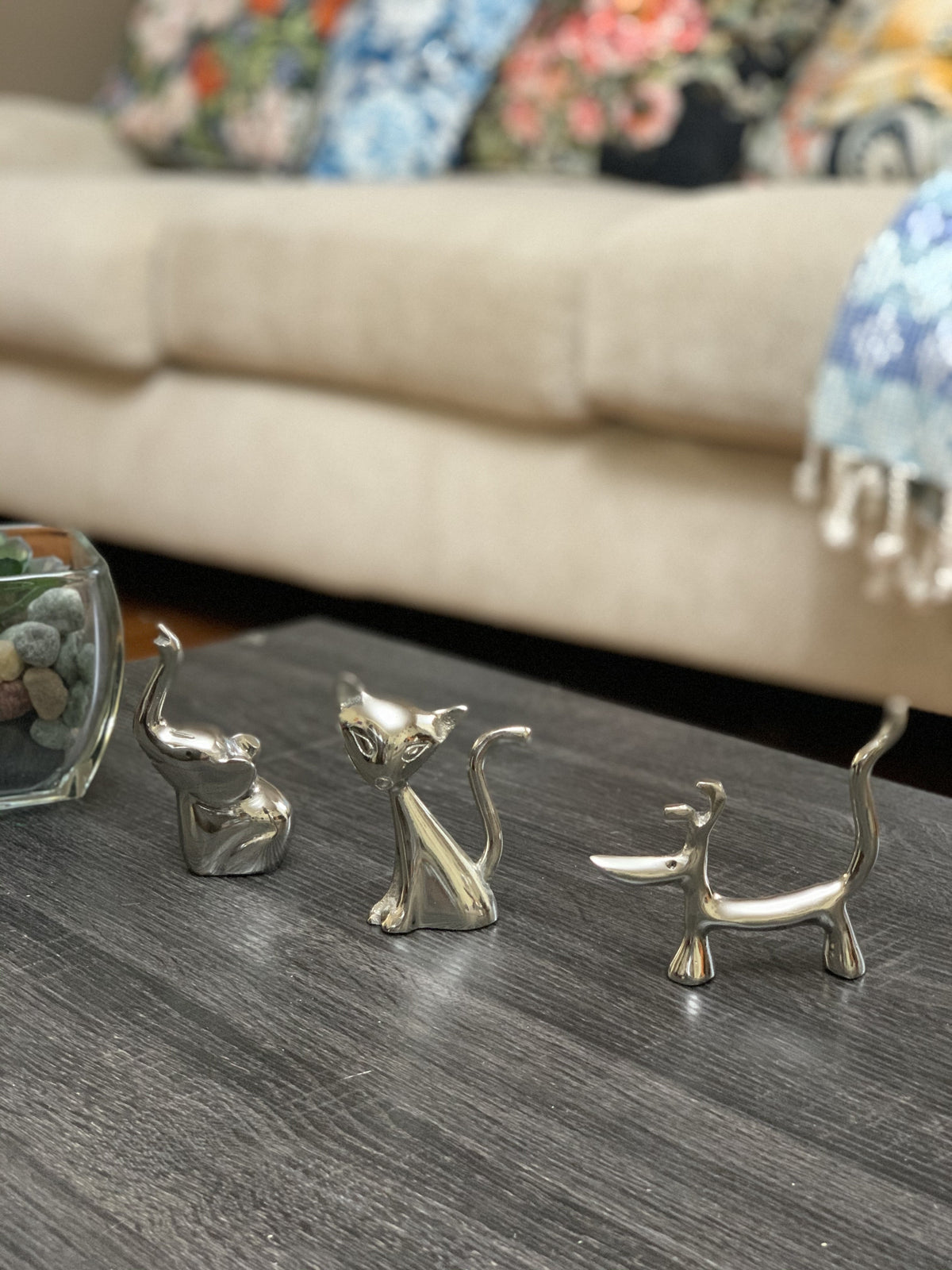 Silver cat and dog ring holder figurines on table