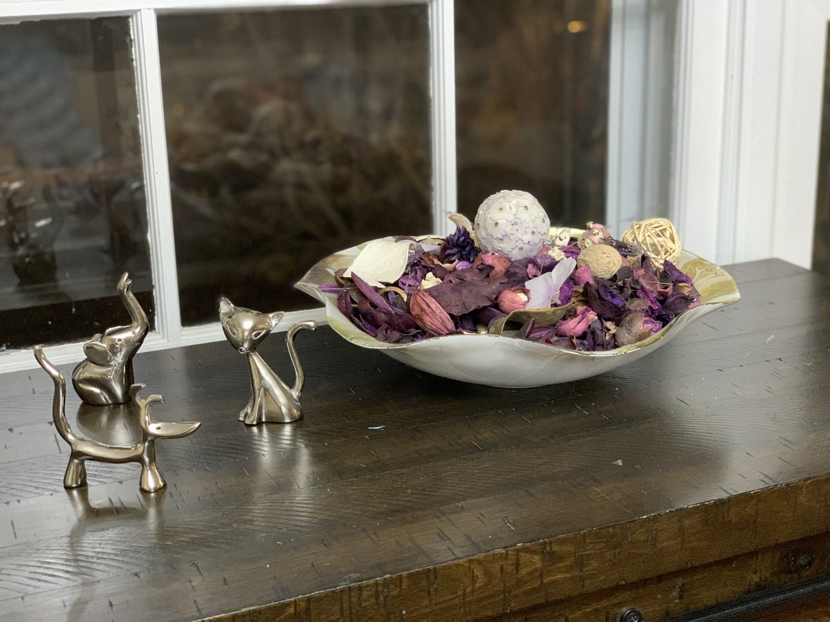 Silver animal ring holders beside a decorative bowl