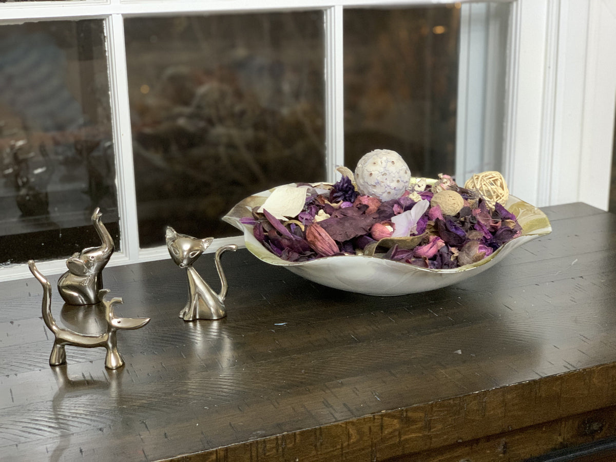 Silver animal ring holders beside a decorative bowl