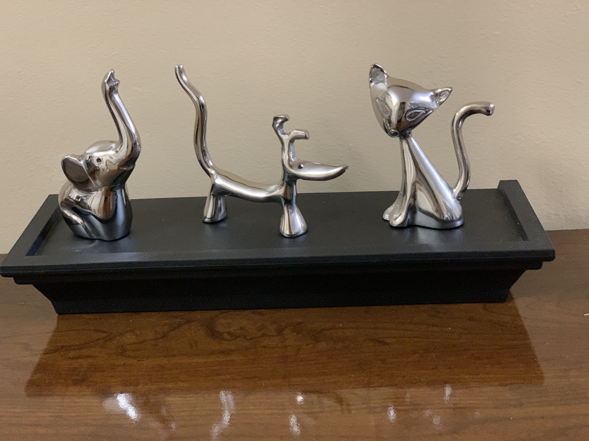 Silver animal ring holders on a black tray: cat, dog, and elephant