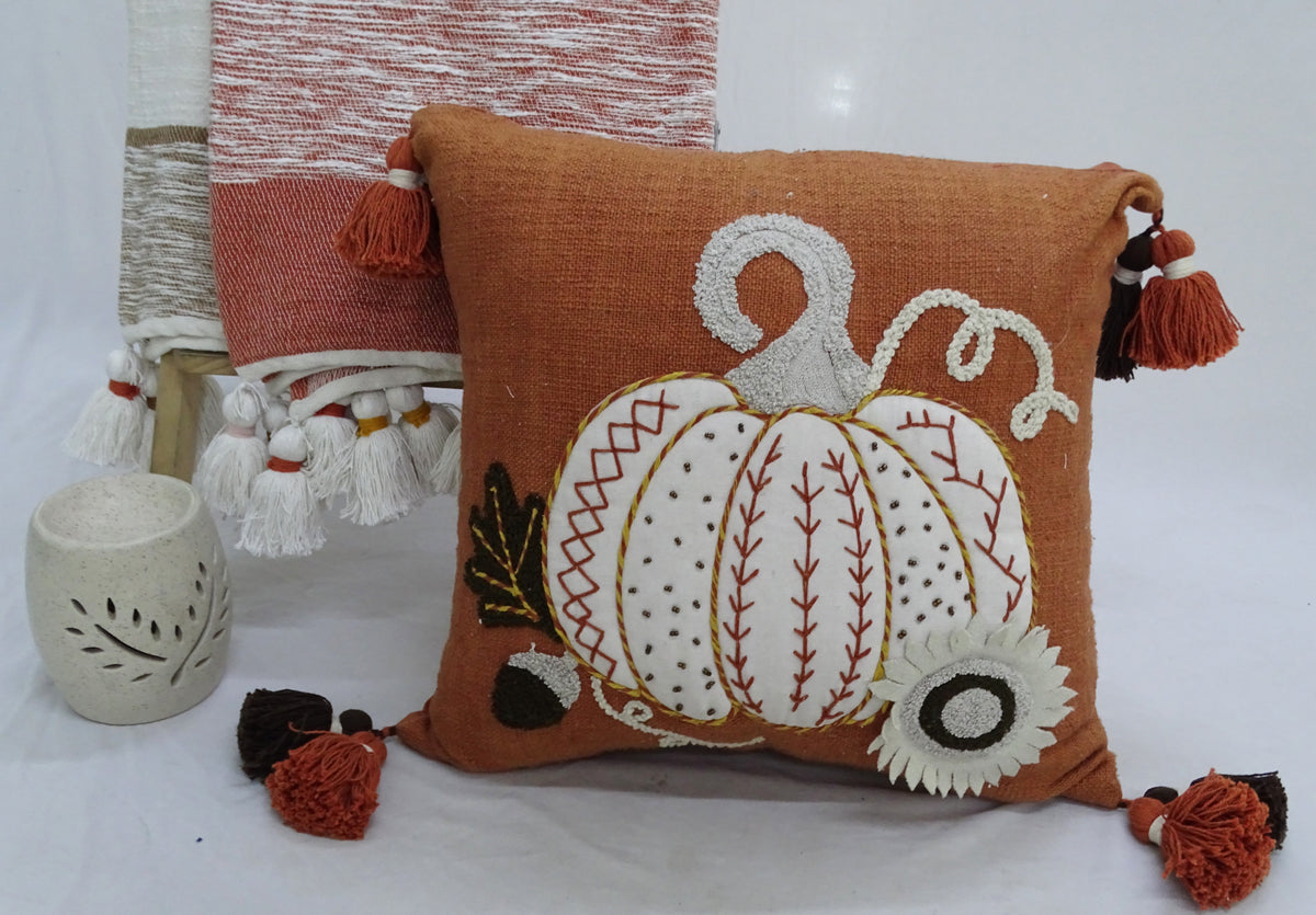 Embroidered pumpkin motif throw pillow in brown fabric with corner tassels