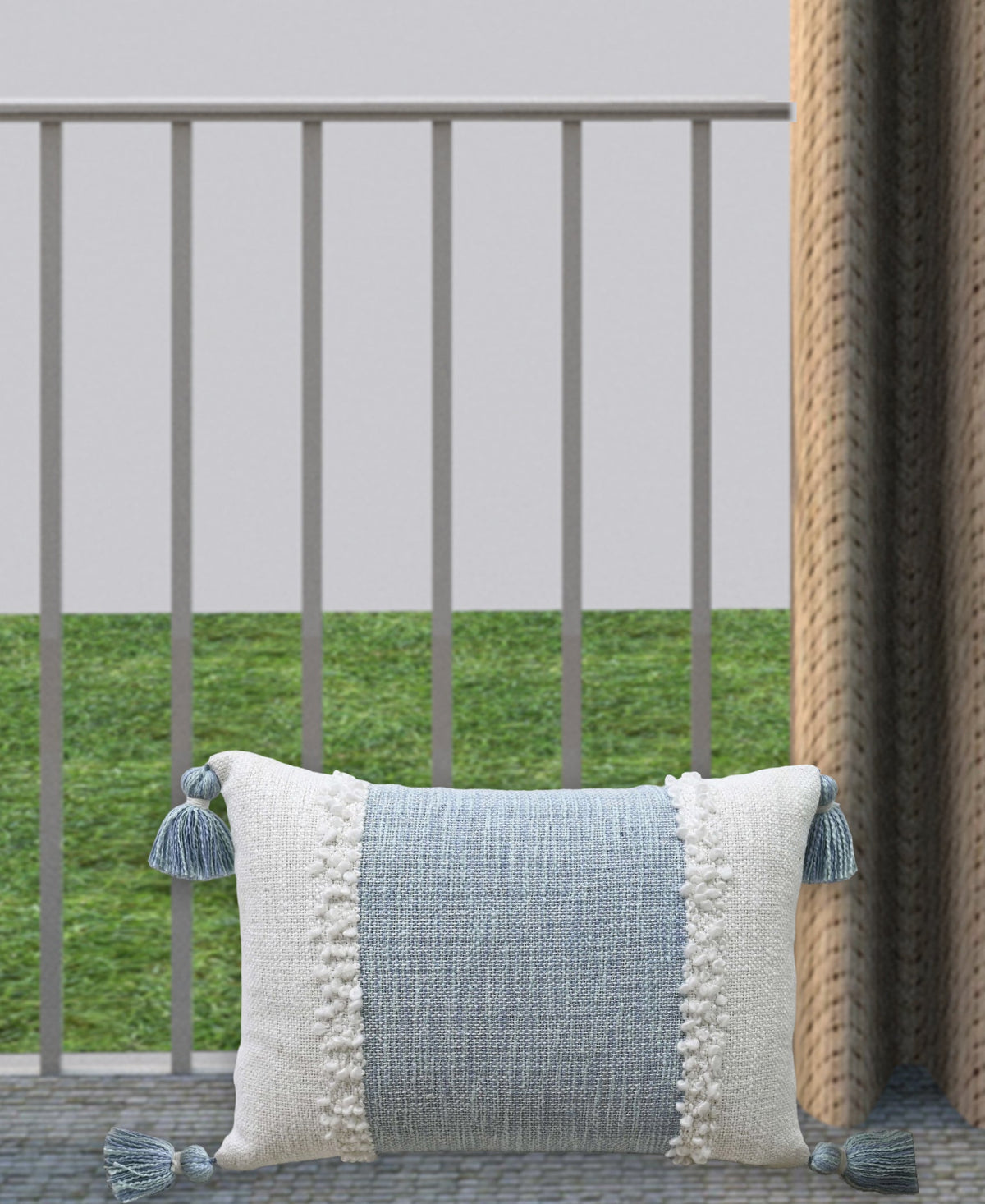 Woven rectangular pillow with light blue front panel and cream pom-pom edge tassels
