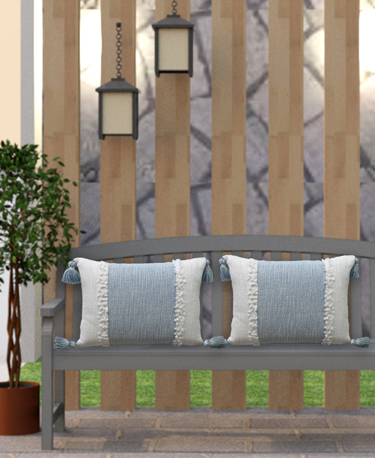 Decorative woven lumbar pillow with blue stripe panel, cream pom trim and tassels