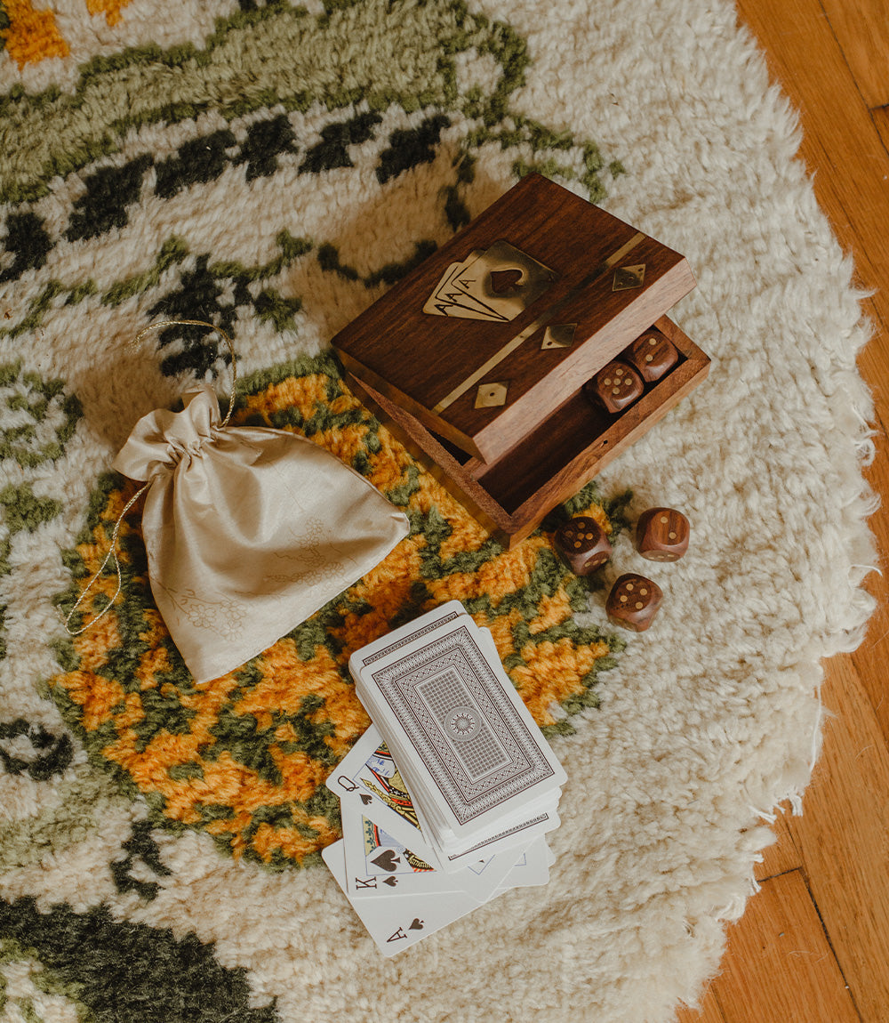 Wooden dice and card set box open with dice, playing cards, and pouch beside it