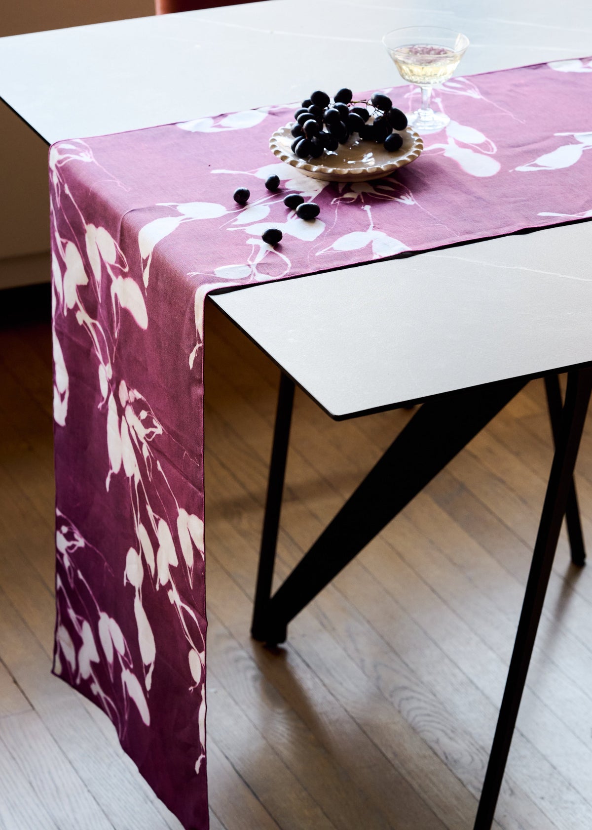 Aubergine table runner with white floral pattern on tabletop