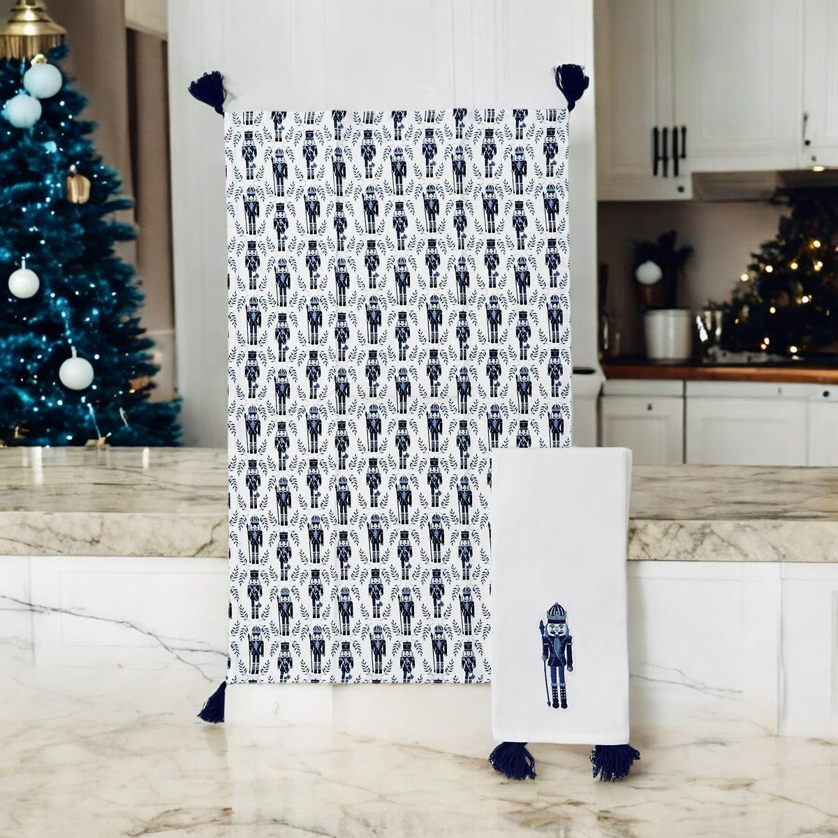 Hanging white tea towel with blue nutcracker pattern and navy tassel fringe, plus label