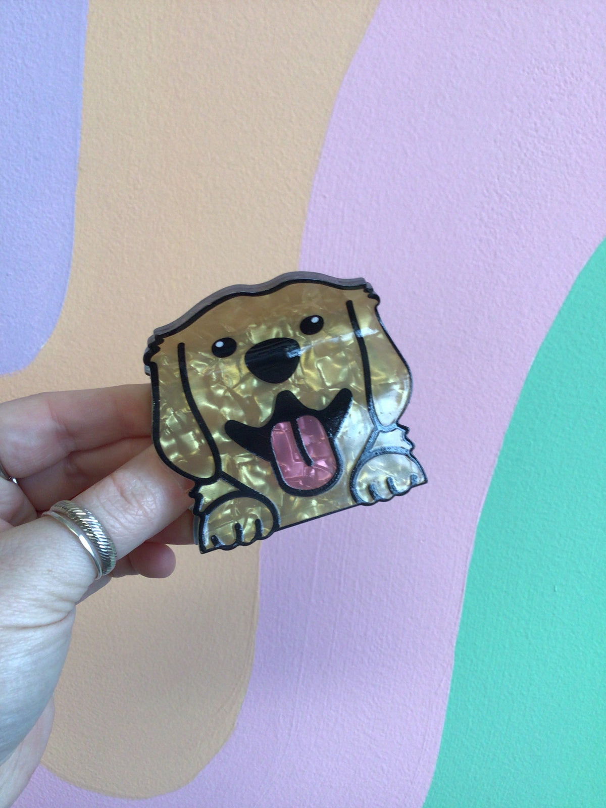 Golden dog hair claw with tongue out, held in hand