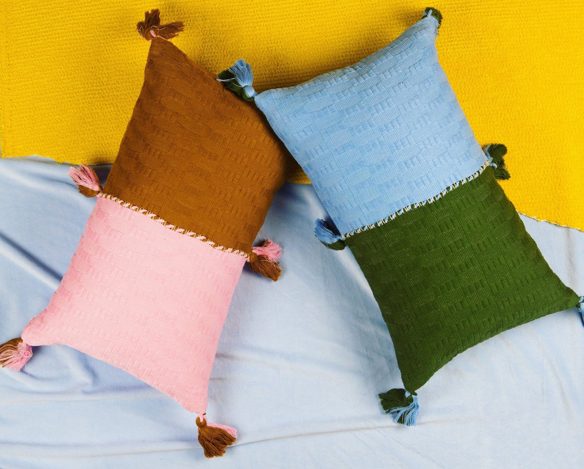Cluster of textured square throw pillows in yellow, blue, pink, and green