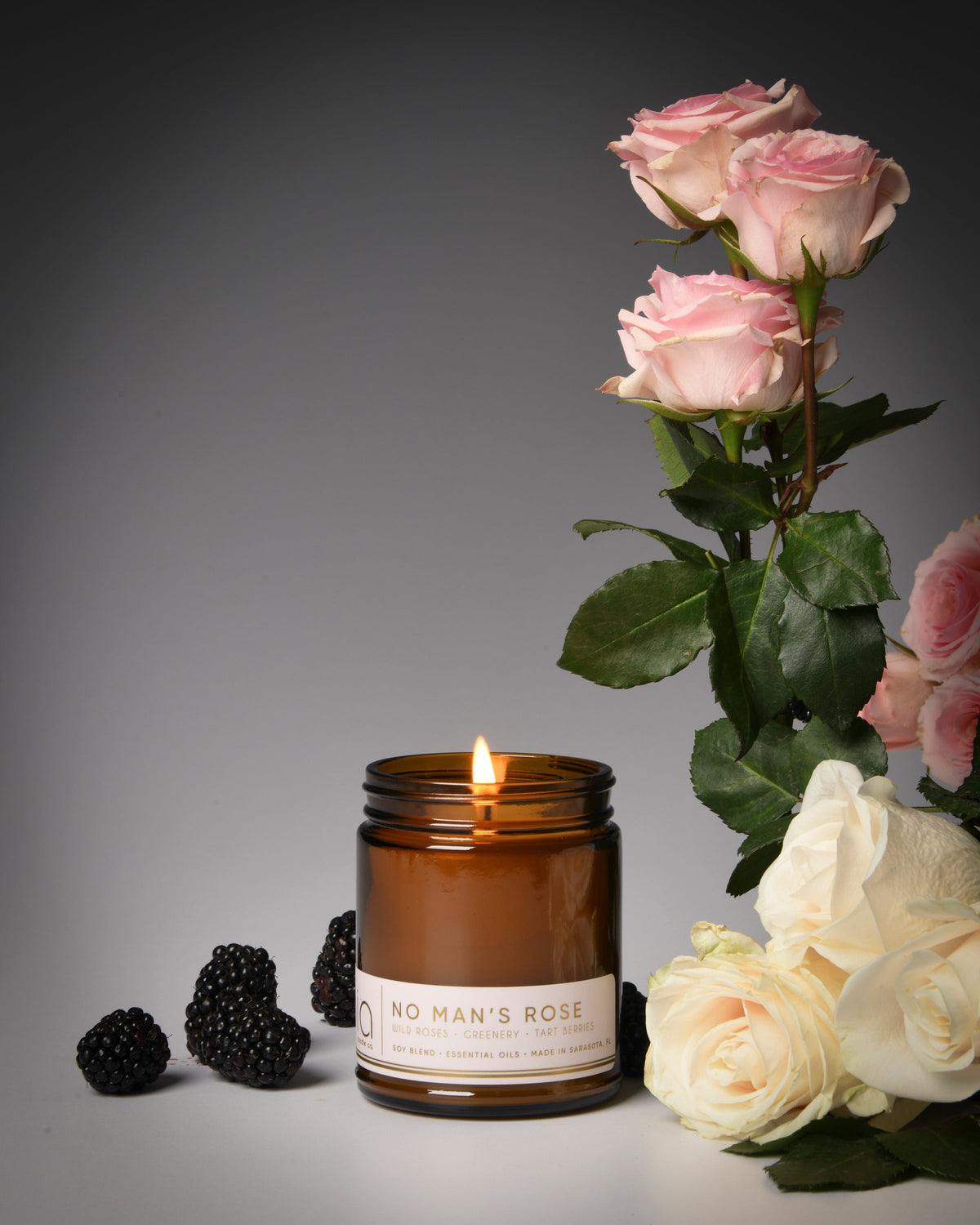 Brown soy blend candle jar with lit wick and printed label